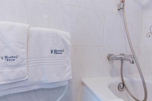 un baño con toallas blancas en un toallero. en Bluebell House, en Windsor