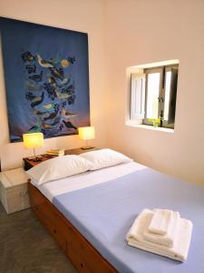 1 dormitorio con 1 cama con 2 lámparas y 1 pintura en La Porta Rossa, en Stromboli