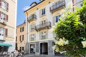 un edificio bianco con balconi su strada di Shades of Como with Private Terrace by Rent All Como a Como