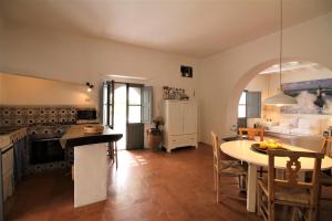 a kitchen and living room with a table and a dining room at La Porta Rossa in Stromboli