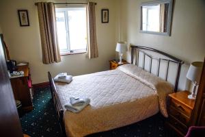 a bedroom with a bed and a dresser at Abbey Grange Hotel in Llangollen