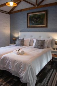 a large white bed with two towels on it at Parkside Guesthouse in Ladismith