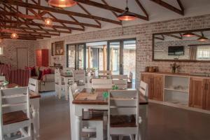 a dining room with white tables and white chairs at Parkside Guesthouse in Ladismith