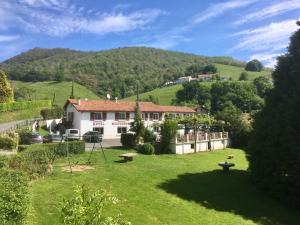una casa en una colina con un patio de hierba en Manexenea, en Saint-Étienne-de-Baïgorry