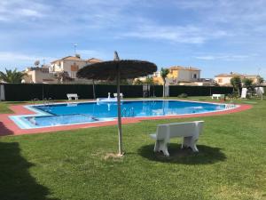 an umbrella sitting in the grass next to a pool at Ferienhaus SUNSHINE Torrevieja/Spanien in Orihuela Costa