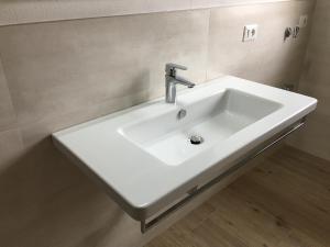 a white bathroom sink with a faucet on a wall at Casa Eva in Bibione +32 photos