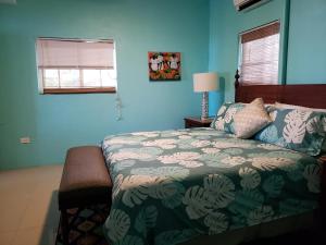 a bedroom with a bed and blue walls at Villa Indigo Sunny 1BR Apartment in Private Gated Estate in Charlotte Amalie