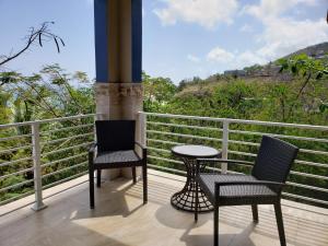 two chairs and a table on a balcony at Villa Indigo Sunny 1BR Apartment in Private Gated Estate in Charlotte Amalie