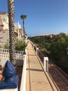 a walkway next to a house with a palm tree at Ferienhaus SUNSHINE Torrevieja/Spanien in Orihuela Costa