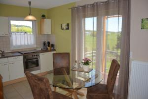 cocina con mesa de cristal y sillas y ventana en Gästehaus Celine, en Meuspath