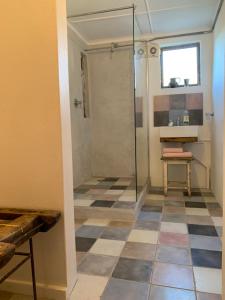 a bathroom with a shower and a tiled floor at The Karoo Moon Motel in Barrydale