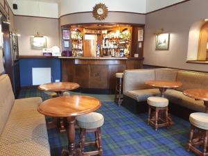 een bar in een pub met tafels en stoelen bij The Imperial Hotel in Castle Douglas