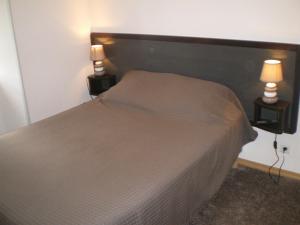 Le NayracにあるL'Auberge Fleurieのベッドルーム1室(ベッド1台、テーブルにランプ2つ付)