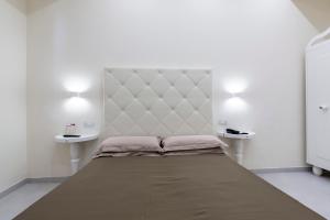 un grande letto in una stanza bianca con due tavoli di Hotel Columbia Wellness & Spa a Montecatini Terme