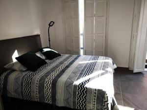 a bedroom with a bed with a black and white comforter at Historic Suites 21 in Cartagena