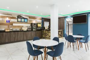 a waiting room with two tables and blue chairs at Days Inn by Wyndham Saint John in Saint John