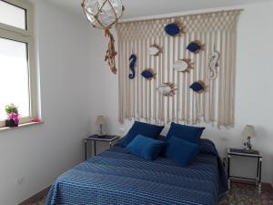 a bedroom with a blue bed with blue pillows at Casa Mina affittacamere in Polignano a Mare