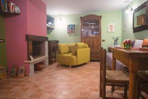 a living room with a yellow chair and a fireplace at Casa di Marina-Trevi in Trevi nel Lazio