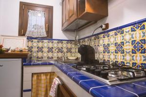 a kitchen with a stove and blue and white tiles at Casa di Marina-Trevi in Trevi nel Lazio