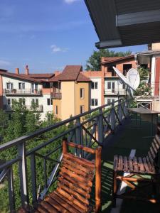 Un balcón con 2 sillas, una mesa y edificios en Giorgi Apartment, en Tiflis