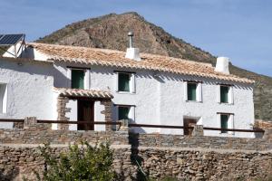 uma casa branca com uma montanha ao fundo em Cortijo El Rancho em Albánchez