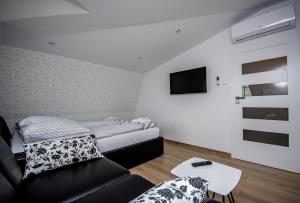 Cette petite chambre comprend un lit et un canapé. dans l'établissement Apartamenty AP 17, à Częstochowa