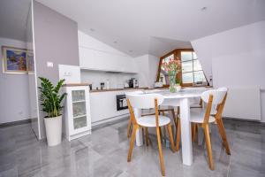 a kitchen and dining room with a white table and chairs at Apartamenty AP 17 in Częstochowa