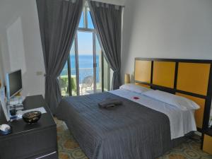 a bedroom with a bed with a view of the ocean at Hotel Holiday in Praiano