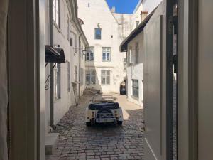 une voiture garée dans une rue dans une ruelle dans l'établissement Old Bishop's House, à Tallinn