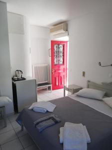 a bedroom with a red door and a bed with towels at Bahia in Hydra