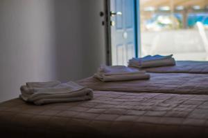three stacks of towels sitting on top of a bed at Romantika in Platis Gialos