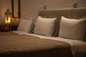 a hotel room with a bed with white pillows at Romantika in Platis Gialos