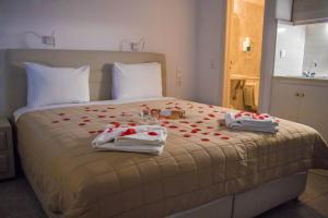 a bedroom with a bed with towels and roses on it at Romantika in Platis Gialos