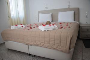 a bed with a teddy bear sitting on top of it at Romantika in Platis Gialos