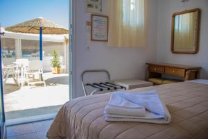 a bedroom with a bed and a patio with an umbrella at Romantika in Platis Gialos