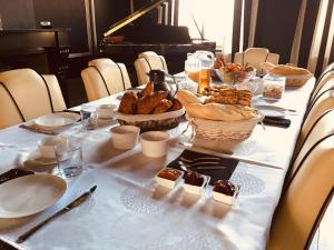 - une table avec du pain et des viennoiseries dans l'établissement Maison De Plumes, à Heuchin