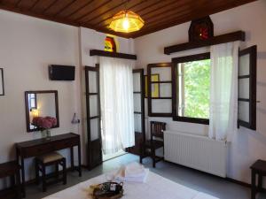 Habitación con ventana, mesa y espejo. en Hotel Vrionis en Agios Dimitrios