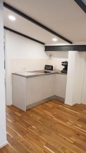 a kitchen with white cabinets and a wooden floor at La casa degli ulivi in Lierna