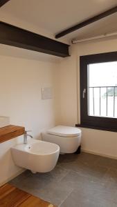 a bathroom with a white toilet and a sink at La casa degli ulivi in Lierna