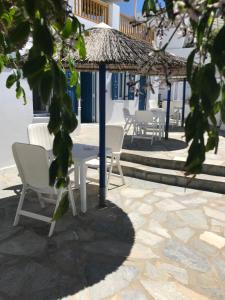 a table and chairs and an umbrella on a patio at Romantika in Platis Gialos