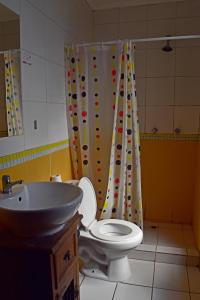 y baño con aseo y lavamanos. en Landay Hostel en Santiago