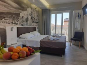 a hotel room with a bed and a bowl of fruit at Rooms Dream Tropea in Tropea