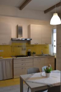 a kitchen with a table and a yellow wall at Appartamento il Riccio in Portoferraio