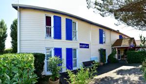 a white and blue house with blue shutters at Ad Cyber-Hôtel in LʼUnion