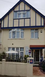 un edificio blanco y azul con mesas y sillas en Blue Waters Lodge, en Paignton