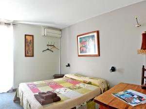 Schlafzimmer mit einem Bett und einem Tisch in der Unterkunft Ad Cyber-Hôtel in LʼUnion