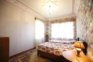 een slaapkamer met een bed en een tafel met een lamp bij Nature House in Koetaisi