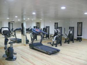 a gym with several tread machines in a room at Qubek Hotel in Balakǝn