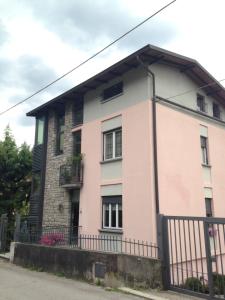 a pink and white house with a black fence at La casa degli ulivi in Lierna