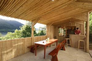 eine Holzterrasse mit einem Holztisch und Stühlen in der Unterkunft Nature House in Kutaissi